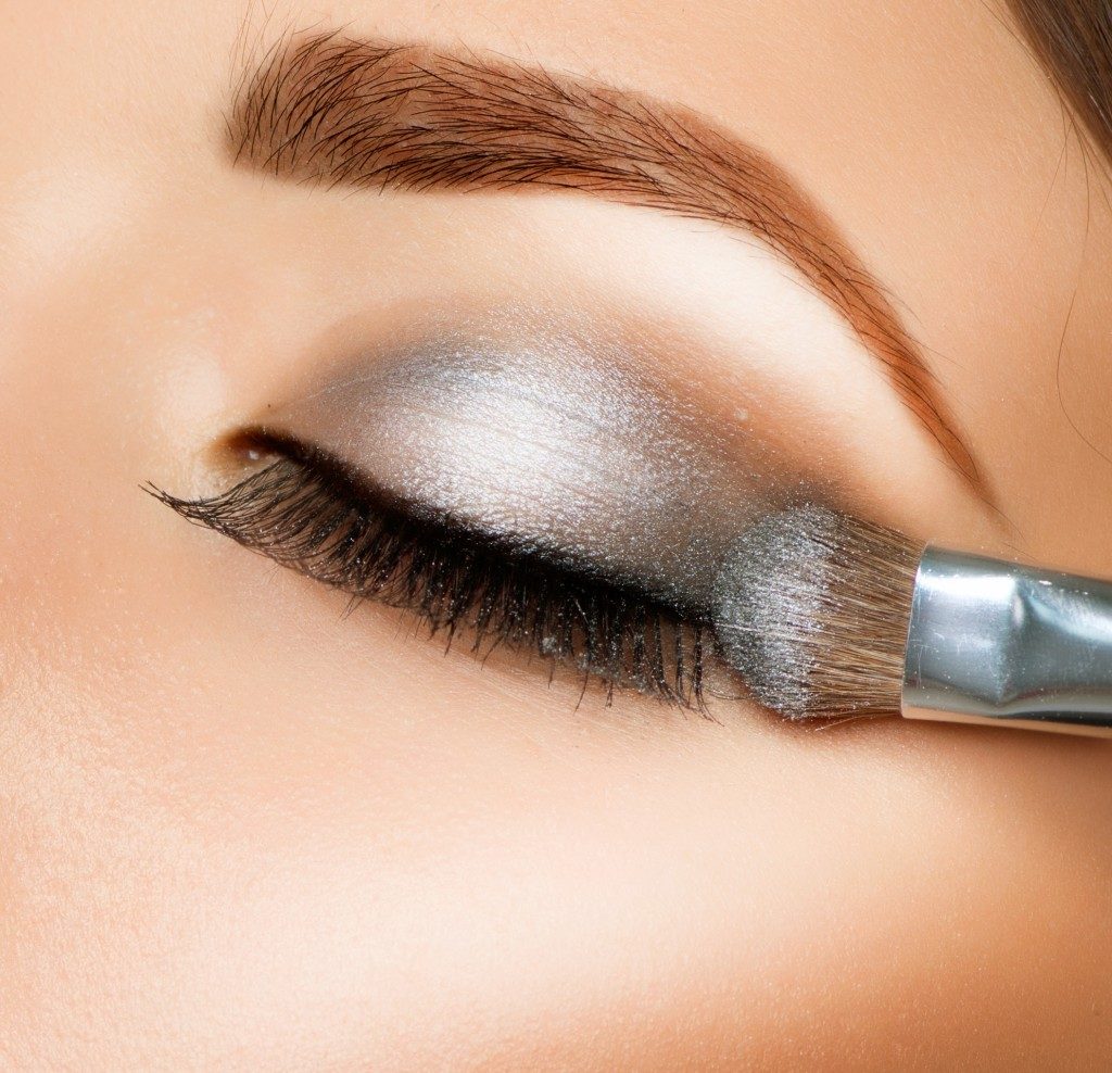 woman applying gray eyeshadow