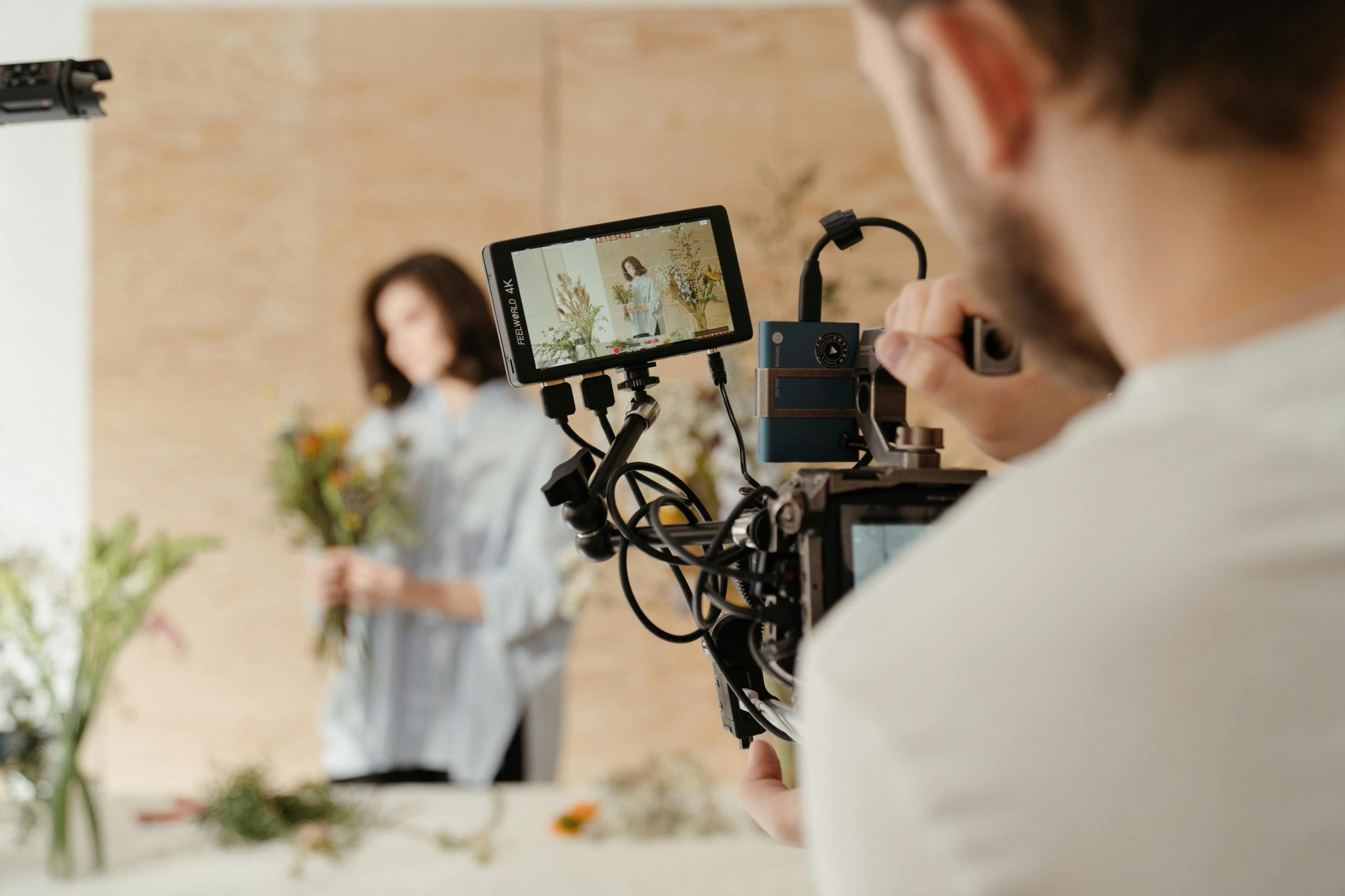 actress on set holding flowers, filmed under high key lighting