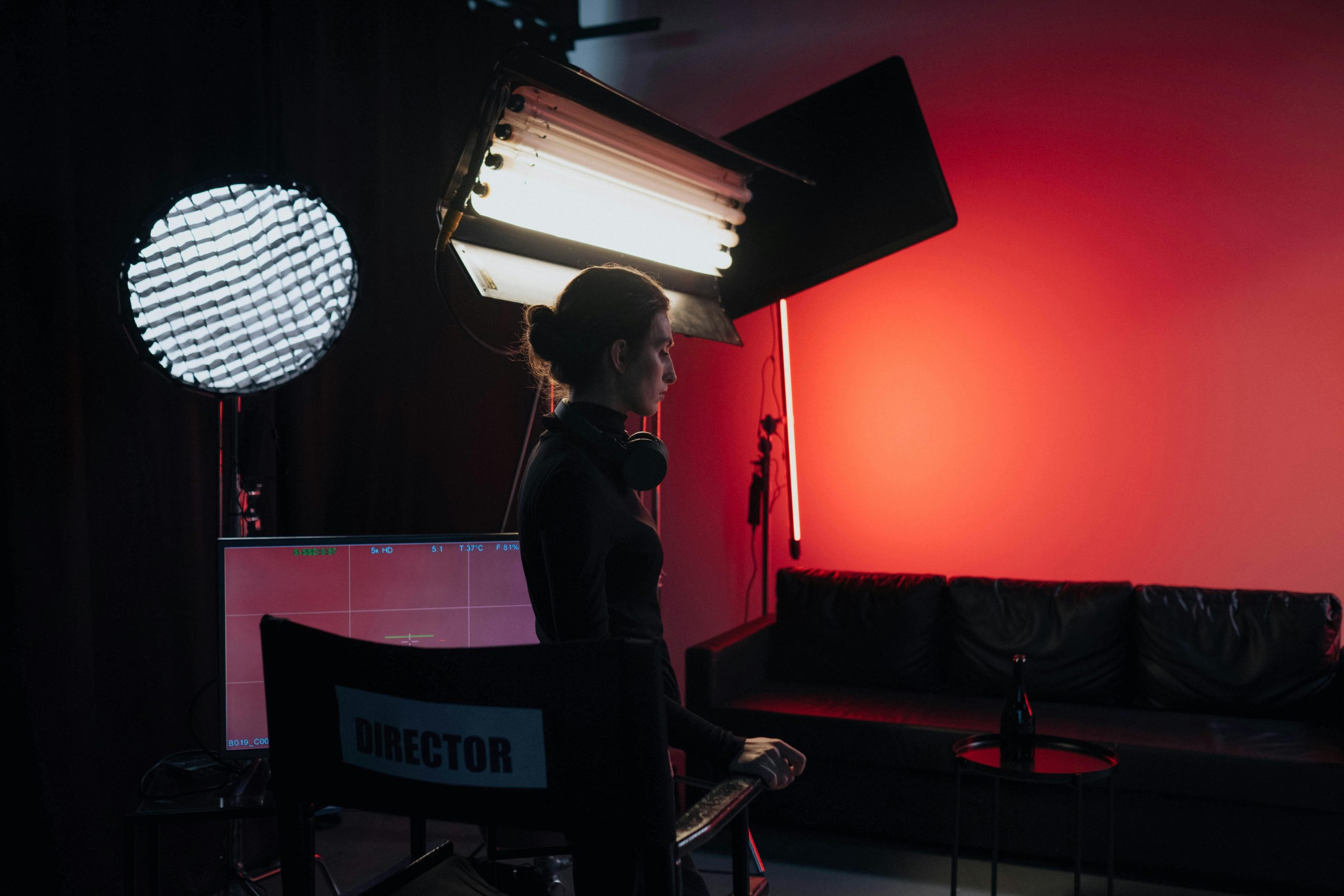 film director standing next to a studio light, with moody low key lighting